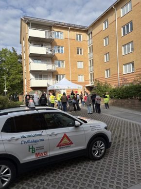 Gårdsträff med en folksamling och en bil framför