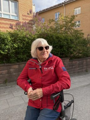 Äldre dam sitter på rullator