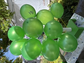 Gröna ballonger vid Haninge Bostäders tält på Haningedagen